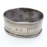 A silver napkin ring with engine turned decoration.