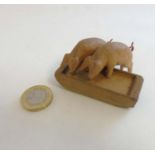 An early - mid 20thC novelty carved wooden toy in the form of 2 pigs feeding from a trough.