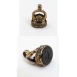 A gilt metal fob seal with engraved hardstone seal under depicting figure with a sickle.