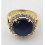 A 14ct (585) gold ring set with cabochon sapphire bordered diamonds CONDITION:
