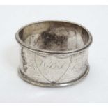 A silver napkin ring with engraved decoration.
