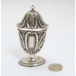 A Victorian silver caster with embossed C scroll and floral decoration.