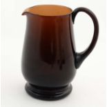 A brown/red glass jug with loop handle 8 1/4" high CONDITION: Please Note - we do