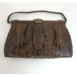 An early 20thC vintage ladies large crocodile skin handbag with head and foot decoration,