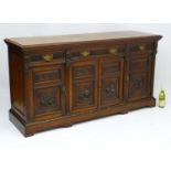 A Victorian walnut three drawer Sideboard with pilaster decoration flanking and separating the four
