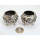 A pair of white metal salts with figural decoration.