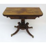 A Regency rosewood pedestal Card Table with storage space within,