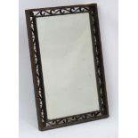 An industrial bronze rectangular mirror with scrolling fretwork decoration to the outer border.