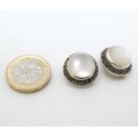 A pair of silver clip earrings set with mother of pearl bordered by marcaiste 3/4" diameter