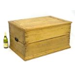 A Victorian pine blanket box opening to reveal storage space within, flanked by cast iron handles.