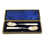 A cased pair of silver plate and mother of pearl preserve spoons with silver collars hallmarked