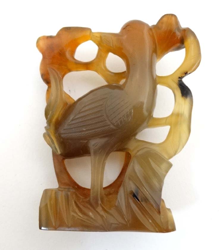 A carved russet jade ornament of a bird amongst foliage. - Image 2 of 5