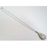 A silver locker of drop form with engraved decoration 1 ½” long on a silver chain 16” long