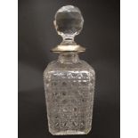 A cut glass decanter and stopper, the stopper with silver surround hallmarked London 1912.