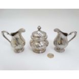 A pair of German .800 silver cream jugs together with a German .