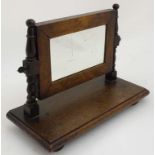 An early 19thC walnut toilet mirror having turned supports and finials to top,