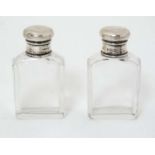 A pair of glass bottles with silver tops hallmarked London 1924 maker A&C? 2 3/4" high