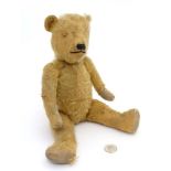 A vintage early 20th C brown mohair teddy bear with articulated limbs,