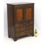 A Georgian mahogany drinks cabinet with cupboard over three graduated drawers.