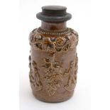 A Stoneware flask decorated with image of a young Bacchus to side and grapevine border with pewter