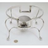 A large silver plated four footed stand with spirit burner.