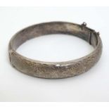 A hallmarked silver bracelet of bangle form with engraved decoration CONDITION: