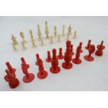 A late 19th C complete set of chess pieces made from ivory and red stained ivory,