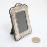 A small photograph frame with silver surround with bow swag and harebell decoration.