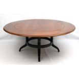 A late 20thC hardwood metamorphic circular extending dining table.