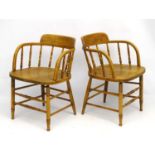 A pair of elm kitchen chairs with open arms and circular shaped backs 29" high