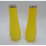 A pair of yellow glass vases with silver collars hallmarked London 1924 maker Henry Williamson Ltd.