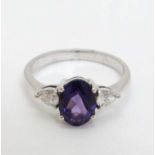 An 18ct white gold ring with central amethyst flanked by diamonds CONDITION: Please