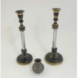 A pair of turned wooden candlesticks with black lacquer and gilt detail and central metal column.