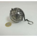 A Chinese white metal pomander of spherical form decorated with birds amongst foliage.