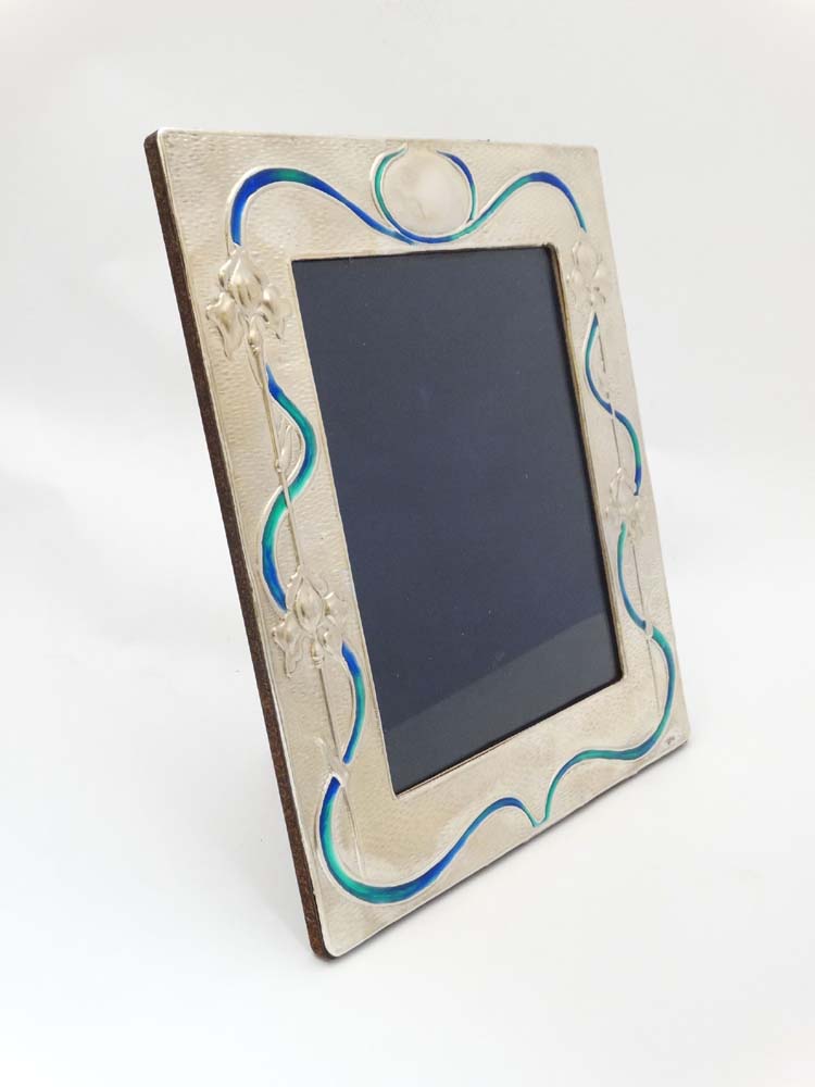 A silver photograph frame with Art Nouveau style enamel decoration.