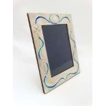 A silver photograph frame with Art Nouveau style enamel decoration.