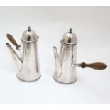 A white metal cafe au lait set with turned wooden handles.