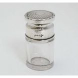 A glass salts bottle of cylindrical form with silver top having engine turned decoration.