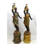 Two mid 20thC painted blackamoor figural electrolier formed as females holding torch aloft on