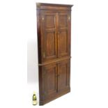 A late 18thC oak floor standing Corner Cupboard with four cross banded doors and original H bracket
