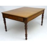 A late 19thC mahogany library table with draws at opposing ends, standing on baluster turned legs.