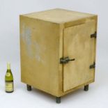 A vintage blonde wood ice box / cooler standing on four cylindrical metal feet.