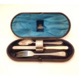 A cased christening set comprising fork spoon knife and napkin ring.