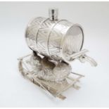 A 21stC novelty silver plate spirit flask formed as a bear reclining upon a sledge with paws aloft