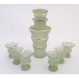 A retro pale green glass decanter and stopper of tapering from with gilt banded detail together