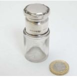 A glass salts bottle and stopper with silver screw top hallmarked Birmingham 1918 maker Selfridge &