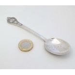 A silver Christening spoon with scroll decoration.