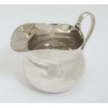 An Art Deco silver cream jug with loop handle.