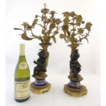 A pair of 19thC gilded bronze and painted bronze candelabra with decorated ceramic socles and