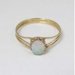 A yellow metal ring set with opal cabochon.